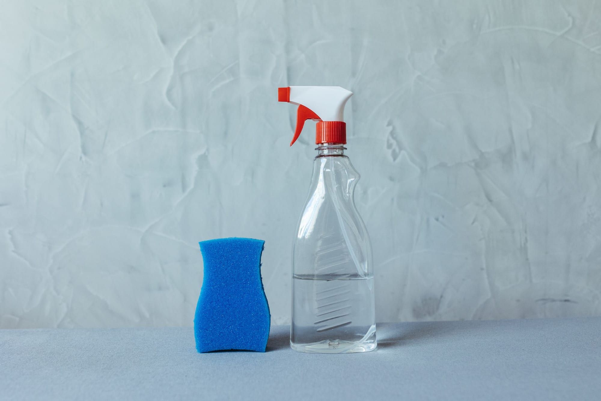 Sprayflaska och blå tvättsvamp